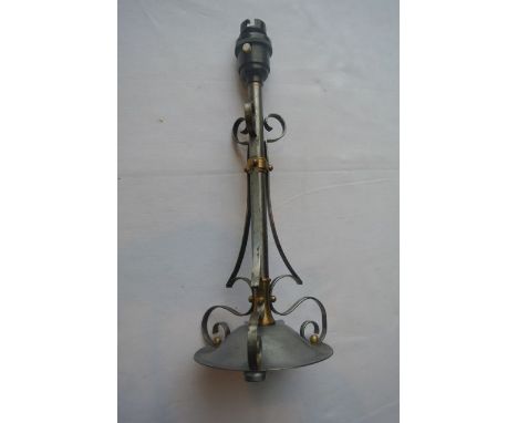 A polished metal Arts &amp; Crafts style table lamp with scrolling supports, brass collars and bakelite fitting