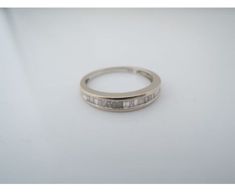 A half eternity diamond ring, channel-set with tapering baguettes, in 18ct white gold, size K 1/2