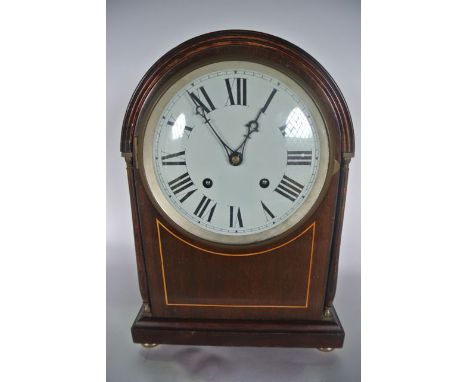 An Edwardian mahogany mantle clock with arched outline and string inlaid detail with 8 day striking movement 