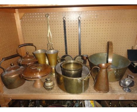 A collection of copper and brasswares to include an extensive brass pan with applied iron handle, a large brass draining ladl