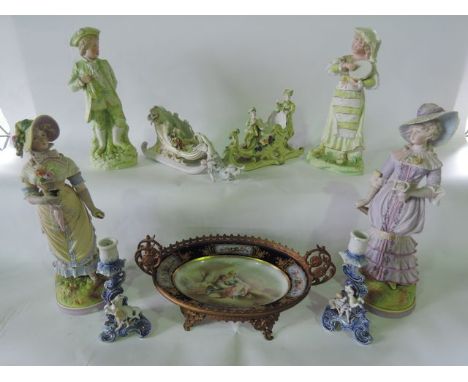 A collection of late 19th century continental ceramics including a pair of bisque figures of elegant ladies, raised on circul