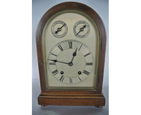An Edwardian mahogany mantle clock, the arched case enclosing a silvered dial with two train movement with chime and silent s