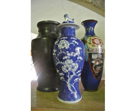 A Japanese cast metal vase of tapering baluster form with incised and further applied decoration of prunus blossom, birds in 