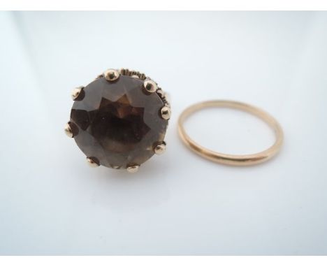 A smoky quartz ring, centred with an untested round mixed-cut smoky quartz weighing approximately 12.60cts, in 9ct gold, size