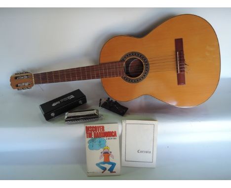 A contemporary Spanish acoustic guitar together with a cased Huang Professional harmonica, a Corista Guitar Chord Finder toge