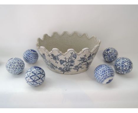 A reproduction 18th century style planter with blue and white painted decoration, shaped border and moulded masks, containing