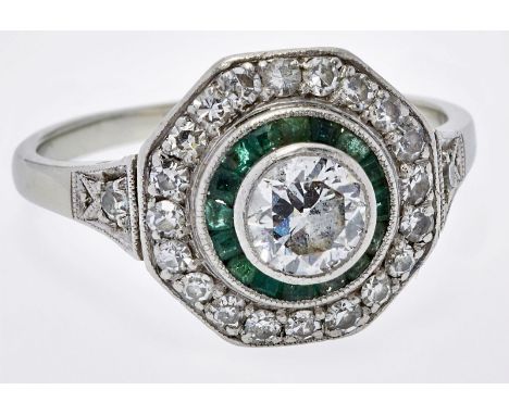 Diamant-Smaragd-Ring, Art Déco,um 1925-30. 18 kt WG, mittig besetzt m. 1 Altschliff-Diamant v. ca. 0,65 ct umgeben v. 16 kl. 