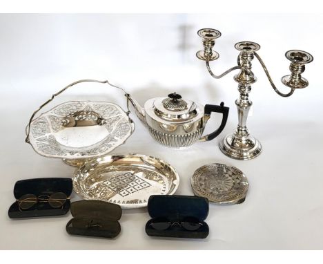 A collection of plated ware including candelabra, tea pot, bonbon dish, boxed flatware, and three pairs of spectacles.