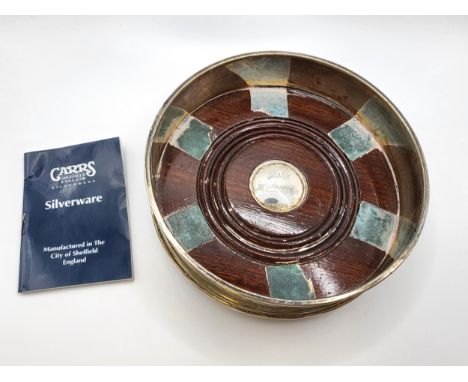 A Carrs' silverware wood and silver coaster for wine bottle with a central bosse engraved 'John Wilkinson' and with a green b