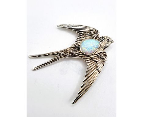 A sterling silver brooch in the shape of a swallow, with an opal panel and a spinel eye. 5cm x 5cm. 10.0gms