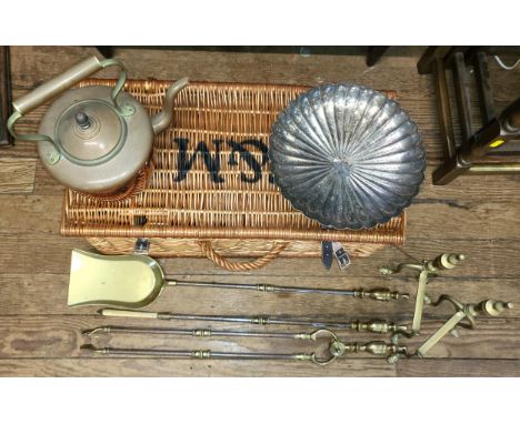 A Fortnum &amp; Masons hamper basket with a selection of brass items including fire utensils, a kettle, and a bowl.