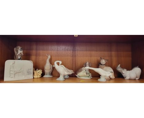 Lladro and Nao figures including geese,  a bloodhound, a hippo, two cats, and a spaniel, and a Lladro plaque.