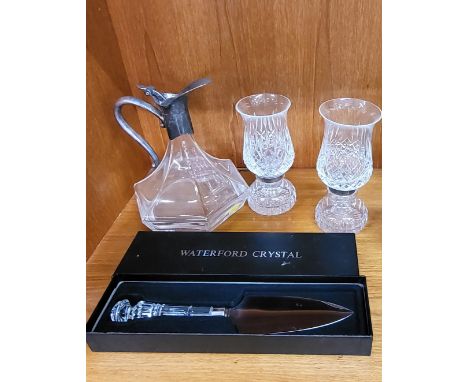 An Art Deco style decanter, a pair of cut glass candle holders (one has a chip), and a Waterford cake slice.