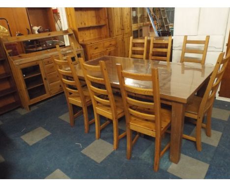 A Pine Dining Room Table and Eight Ladder Back Chairs