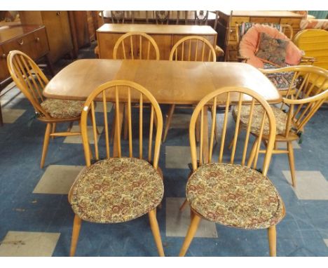 An Ercol Drop Leaf Dining Table with Six Spindle Back Ercol Chairs to Include One Carver