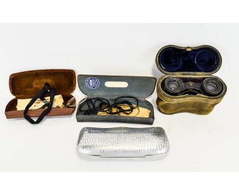 A Pair Of Antique Opera Glasses Housed in original leather case, an unusual example in heavyweight brass with raised hunting 