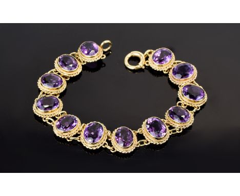 Amethyst Line Bracelet, twelve oval cut amethysts of good colour, totalling 24cts, bezel set in 9ct gold, each with a double 