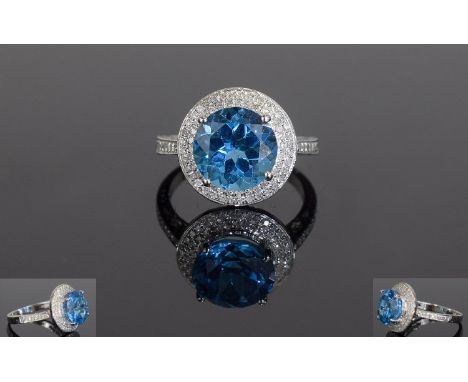 14ct White Gold Blue Topaz & Diamond Ring, Set With A Central Round Topaz (Estimated Weight 5,75ct) Surrounded By Round Brill