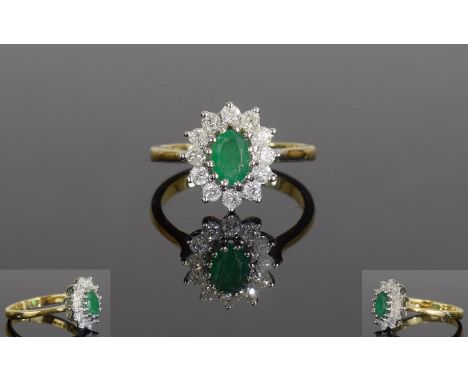 18ct Gold Emerald And Diamond Ring, Set With A Central Oval Emerald Surrounded By Round Modern Brilliant Cut Diamonds. Fully 