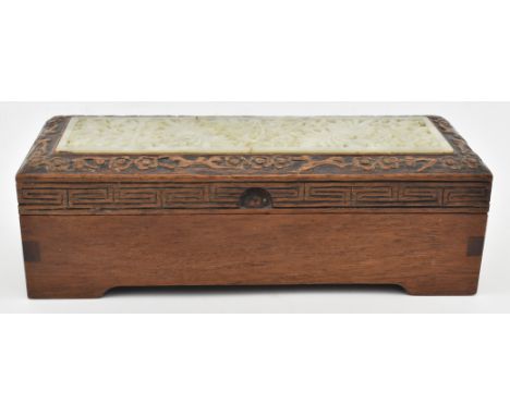 A 20th century wooden box with soapstone plaque inlaid mounted. The oblong hinged lid wooden box decorated with a soapstone j