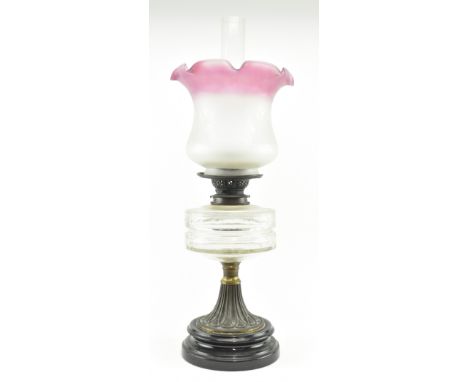 A mid to late 19th century Victorian Neoclassical oil lamp. The oil lamp featuring central glass flue, cranberry two tone fro