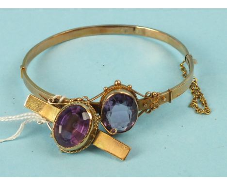 A 9ct gold hinged bangle, collet set an oval amethyst with cannetile decoration, 7.6g and a similar brooch, (af) (2).