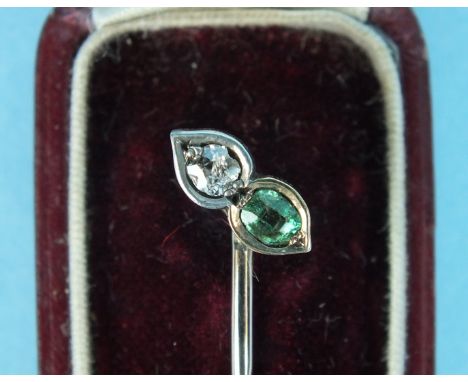 A Victorian stick pin set an emerald and a diamond, in unmarked gold and silver mount, cased.