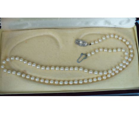 A string of Mikimoto uniform cultured pearls with silver clasp stamped "M", in original box with leaflet and polishing cloth,