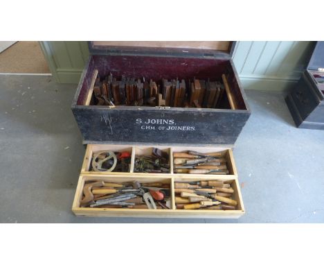 A collection of woodworking tools to include chisels, moulding planes in a vintage carpenters tool chest