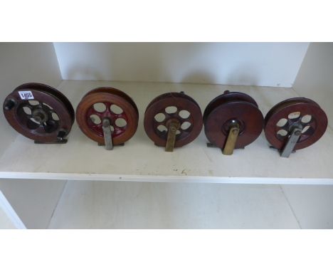 Five vintage wooden fishing reels ranging in size from 17cm diameter to 16cm diameter