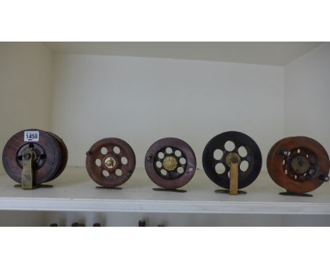 Five vintage wooden fishing reels ranging in size from 13cm diameter to 11cm diameter