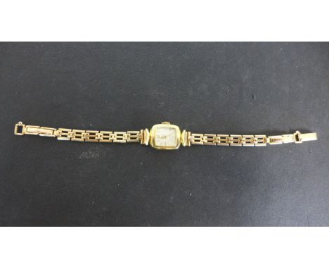 A 14ct yellow gold cased ladies watch with 9ct gold bracelet strap - baton markers to white enamel dial - total weight approx