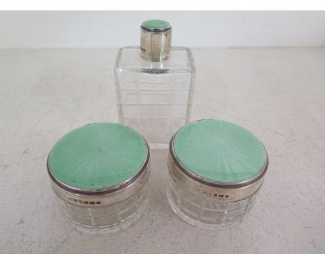 Three Mappin and Webb cut glass bottles with silver enamel tops, London 1936-37Condition report: Some loss and damage to enam