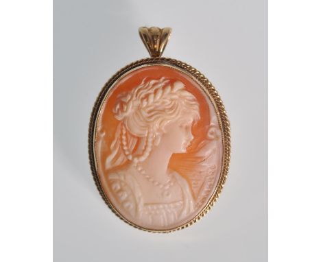 A 20th Century carved shell cameo brooch of oval form set within a 9ct gold mount, the cameo depicting a lady facing right, s