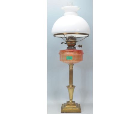 A 19th Century Victorian antique oil lamp raised on a square stepped base with a reeded column with an orange glass reservoir