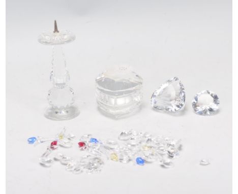 A collection of Swarovski crystal ornaments to include a heart shaped box with florals to the top, a candle stick holder two 