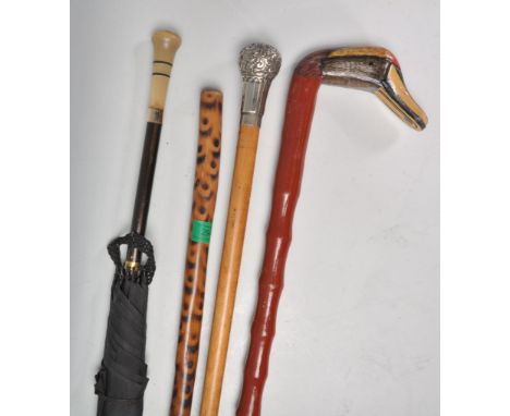 A group of three walking sticks to include a faux bamboo cane with a carved duck head handle, a stick with a white metal knop