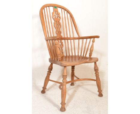 An early 20th Century light oak Windsor armchair / chair&nbsp;being raised on turned splayed legs united by stretcher having 