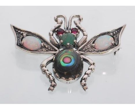 A sterling silver art nouveau style bug brooch set with opal panels and ruby eyes. Gross weight 7.9 grams.&nbsp;