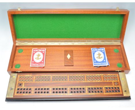 A good mid 20th Century cribbage game board with inlaid decoration and brass ends and game pieces. The board raised on a ebon