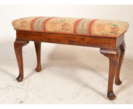 An Edwardian mahogany duet piano stool being raised on cabriole legs with pad feet having hinged top opening to reveal sheet 