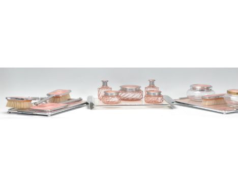 A group of three vintage 20th Century Art Deco dressing sets. All having chrome frames with glass centers to include to pink 