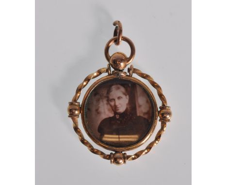 A late 19th Century / early 20th Century Edwardoian 9ct gold mourning pendant of round form having a central photographic pan