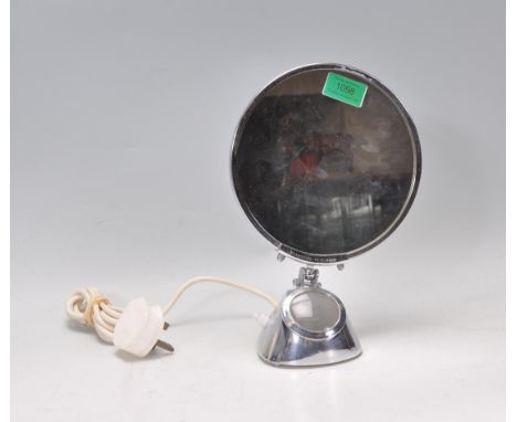 A retro mid 20th Century chrome table top mirror of circular form raised on a shaped chrome base fitted with a light. Marked 