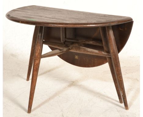 A retro 20th Century 1970's Ercol dark beech and elm&nbsp;circular&nbsp;circular&nbsp;coffee table raised on tapering splayed