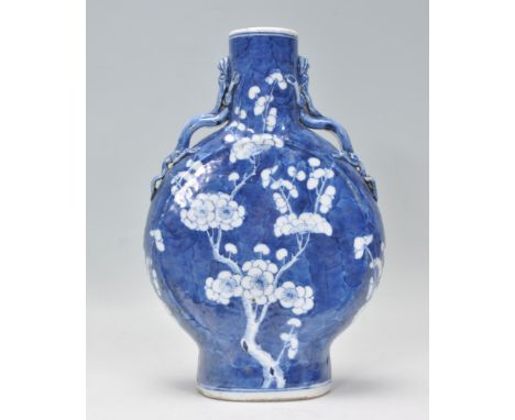 An antique 18th Century Chinese Kangxi prunus pattern moon flask vase in the typical prunus decoration with dragon moulded ha