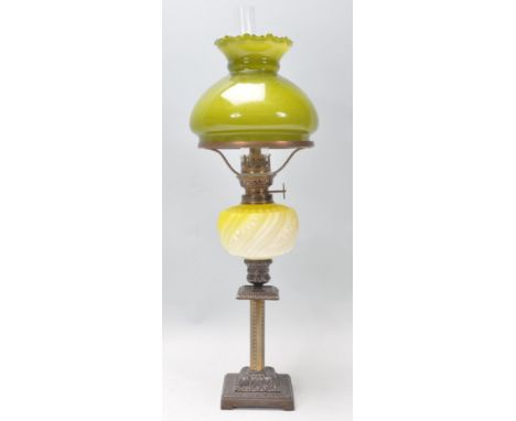 A 19th Century Victorian oil lamp of small proportions being raised on a square stepped base having a yellow glass moulded re