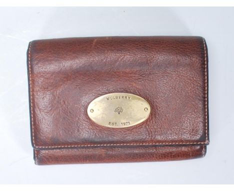 A vintage Mulberry ladies brown leather purse of folding design having a brass oval panel to the front engraved with a mulber