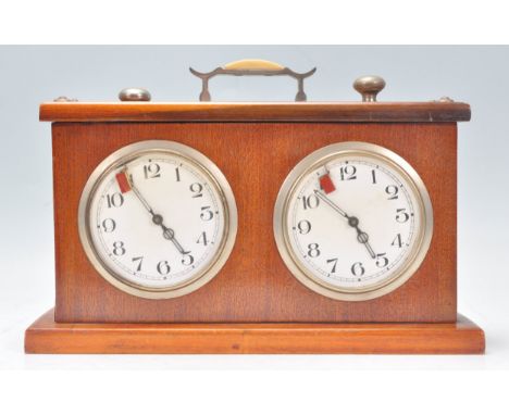 A vintage teak cased chess clock / timer of rectangular form having two white enamelled dials with arabic numerals to the cha