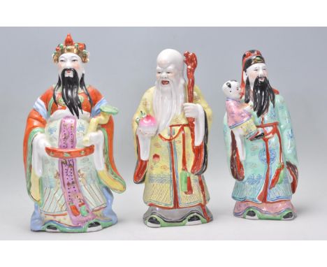 A group of three Chinese polychrome ceramic figures of the Sanxing deities each being hand painted with gilt detailing. Measu